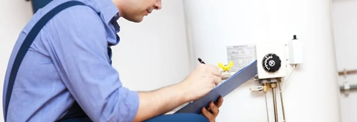 Water heater repair technician inspecting the unit and recording service notes in Omaha, NE
